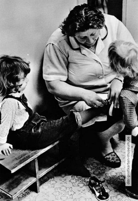 Kindergärtnerin zeigt, wie man sich Schuhe anzieht - 1977
